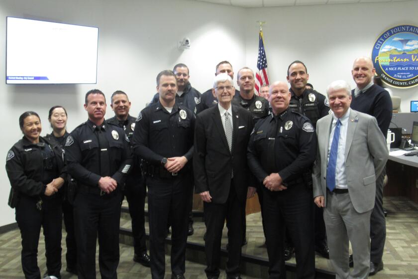Tom Borgquist, front row, center, a retiring Fountain Valley police chaplain, poses for a picture with police department members on Tuesday, Feb. 20, 2024.