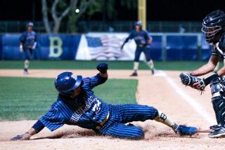 Vince Cervantes of Birmingham slides in safely before Granada Hills catcher Will White receives the throw at home.