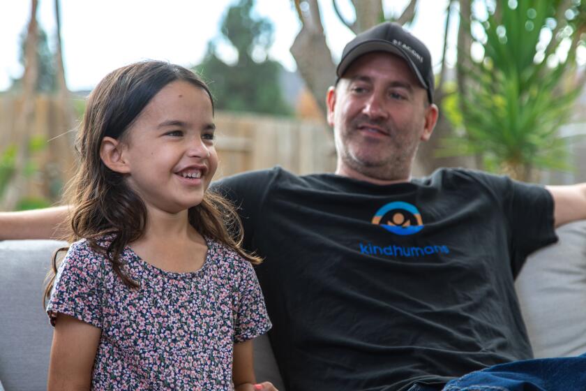 Carlsbad, CA - October 04: Six-year-old Layla sits with her father Shawn Mahoney on Monday, Oct. 4, 2021 in Carlsbad, CA. Layla is one of only 60 kids in San Diego to be part of the clinical trial for the Moderna vaccine. She barely made it into the trial due to a sudden cancer diagnosis. (Jarrod Valliere / The San Diego Union-Tribune)