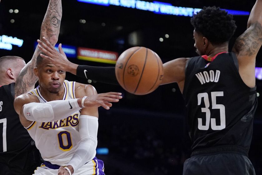 Lakers guard Russell Westbrook passes while under pressure from Rockets center Christian Wood 