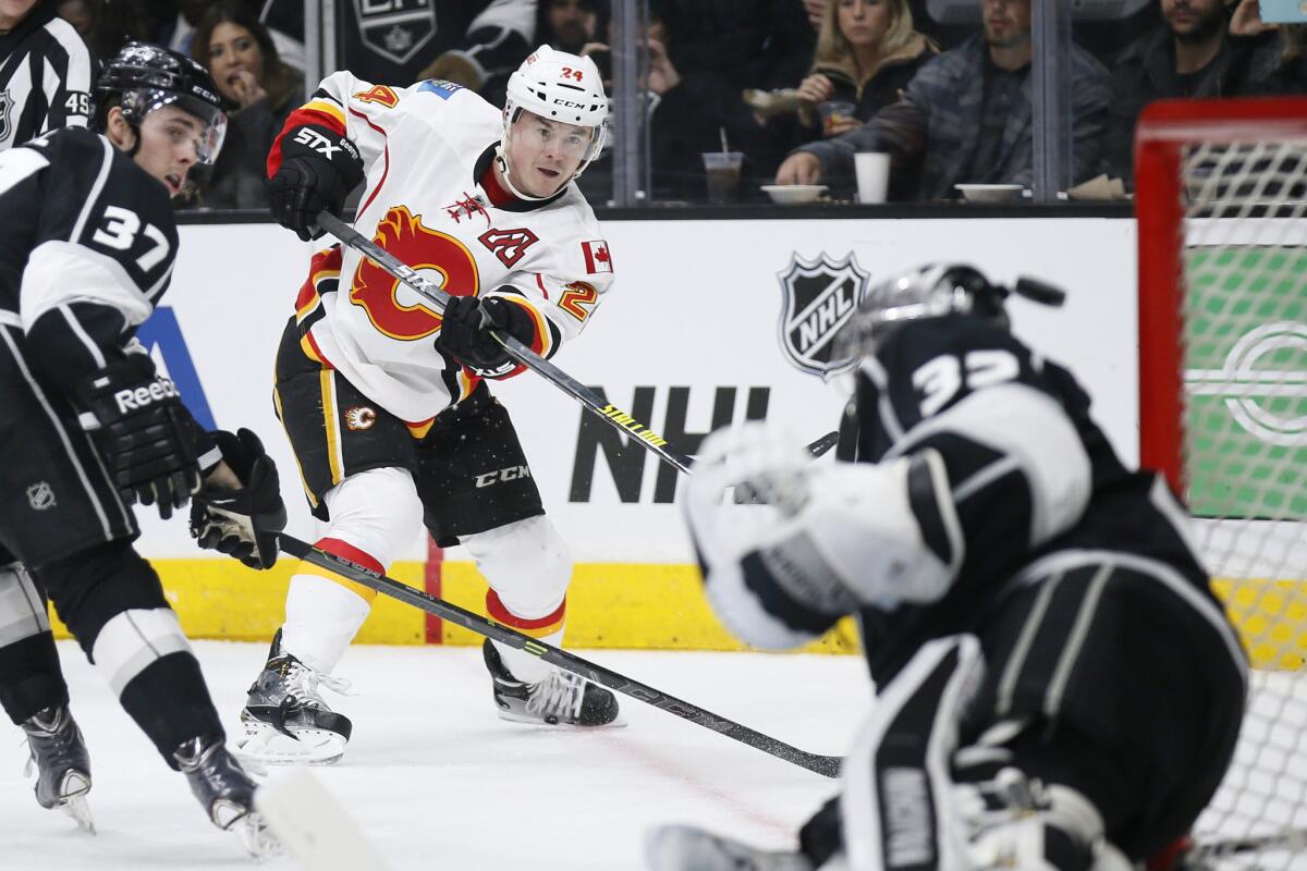 Flames left wing Jiri Hudler misses a shot just past the head of Kings goalie Jonathan Quick while Kings center Nick Shore tries to defend in the first period.