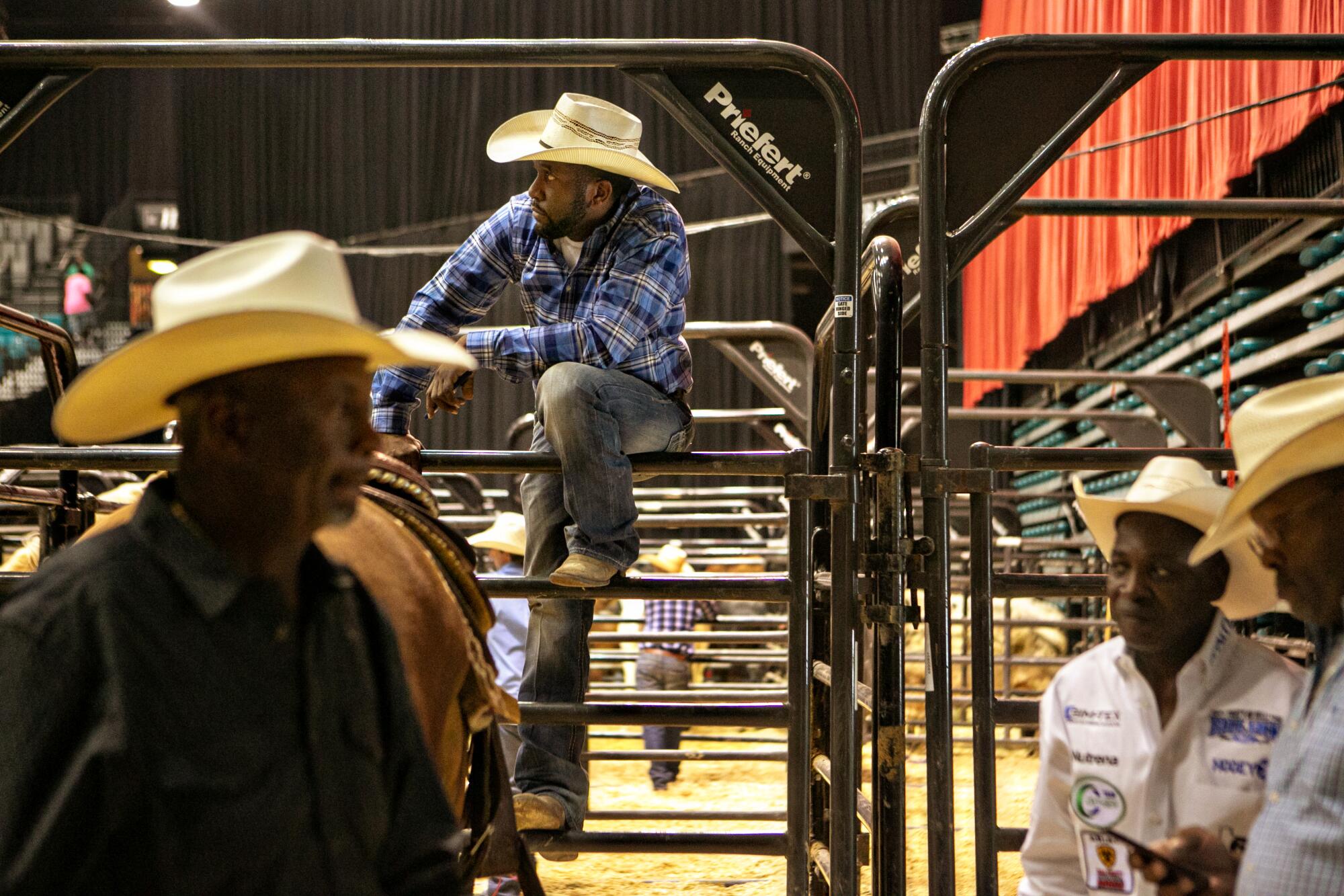 Cowboys gather around the stock holding pens at the Bill Pickett Invitational Rodeo.