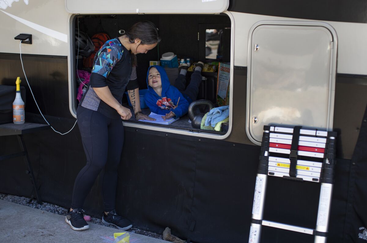 Edith Taylor helps her son with math problems at the family's RV in Flagstaff.