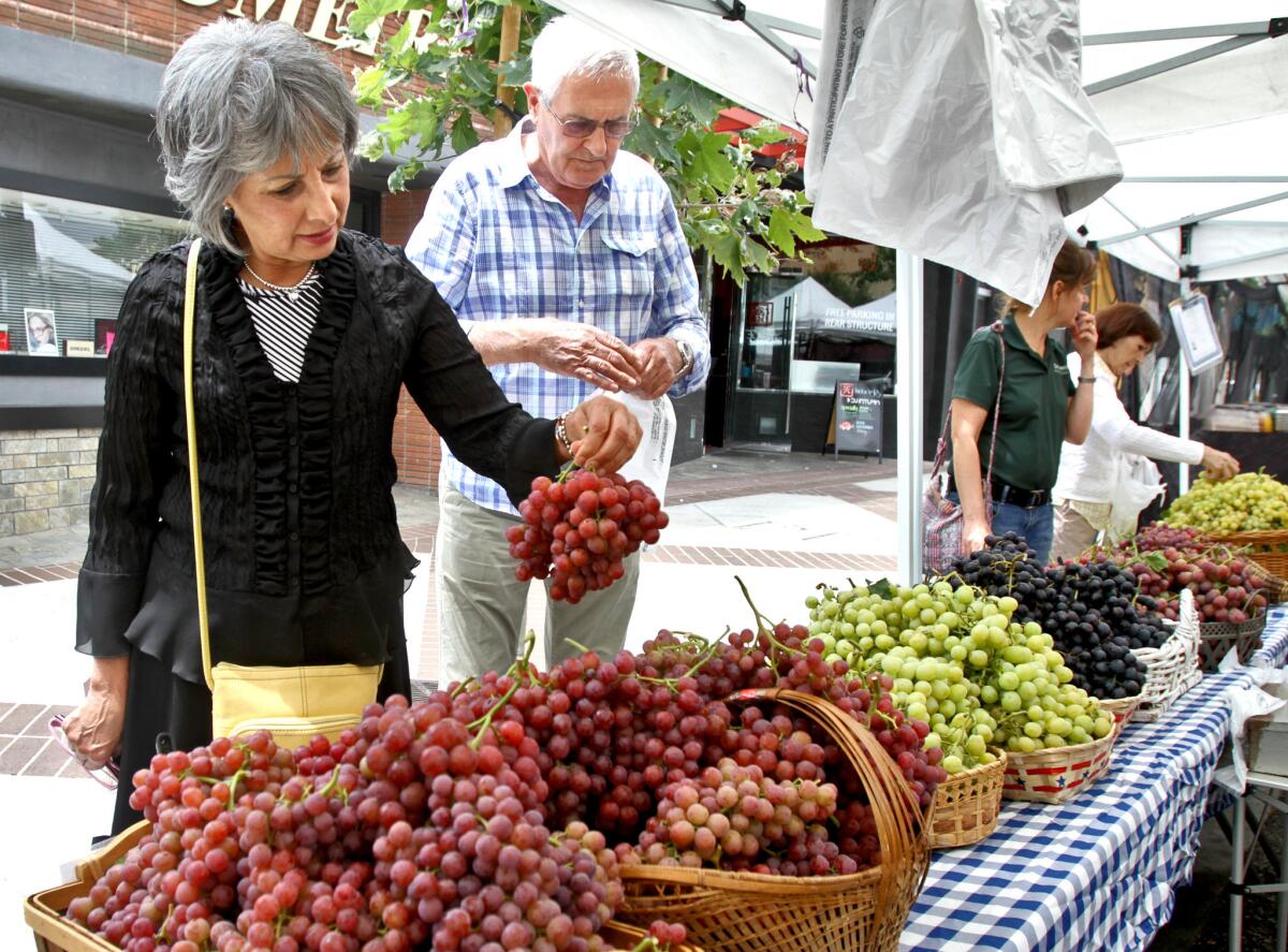 In this July 2015 photo, Mercedes Runstk and her husband Jorge Runstk, visiting from Montclair, got organic grapes at the farmers market in downtown Glendale. About a year after reopening on Brand Boulevard, the farmers market has closed due to poor turnout, and its future is unclear for now.