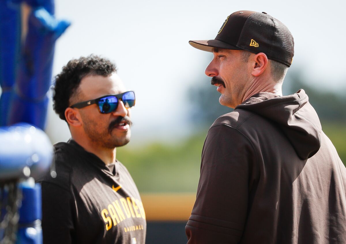 Padres center fielder Trent Grisham, left, and DH Matt Carpenter talk during a spring training practice.