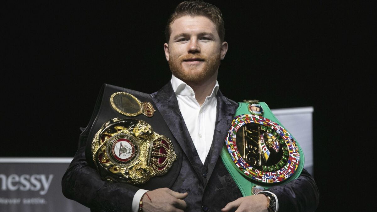Canelo Alvarez poses for photos with his two championship belts at Madison Square Garden.