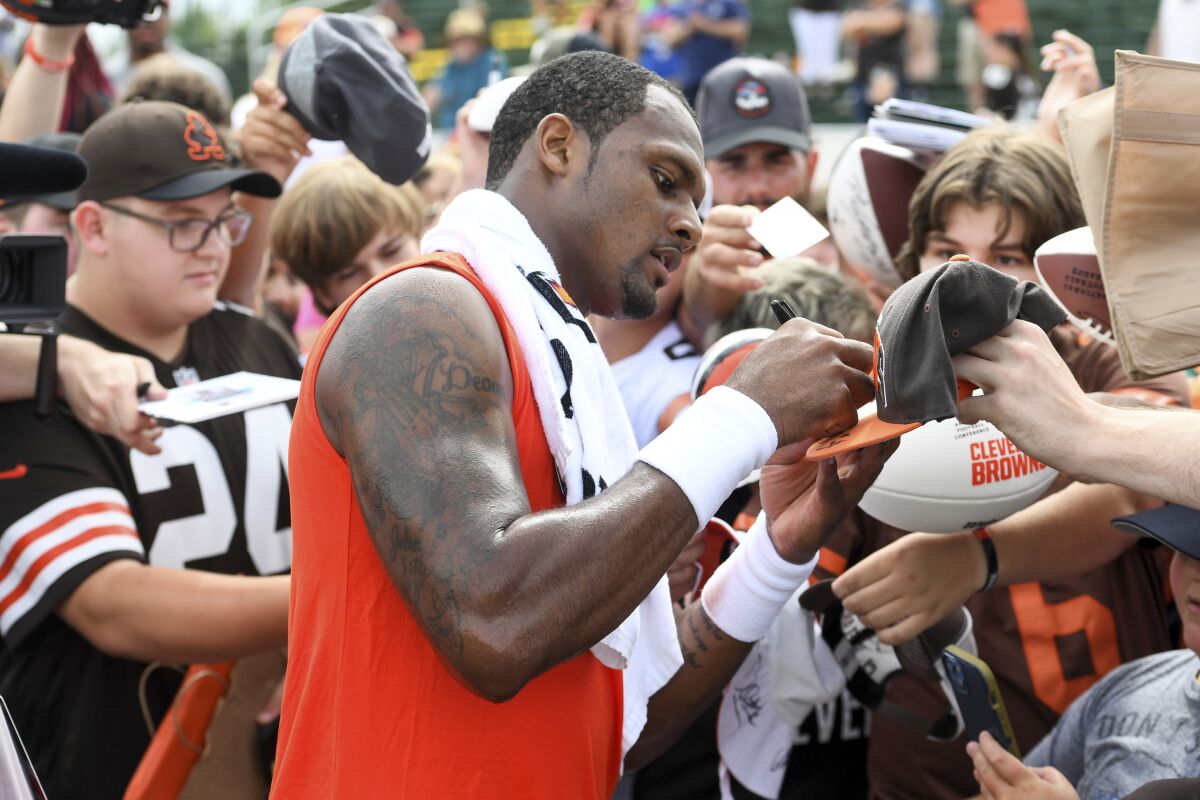 Cleveland Browns quarterback Deshaun Watson gives autographs to fans after the NFL football team's training camp, Monday, Aug. 1, 2022, in Berea, Ohio. (AP Photo/Nick Cammett)