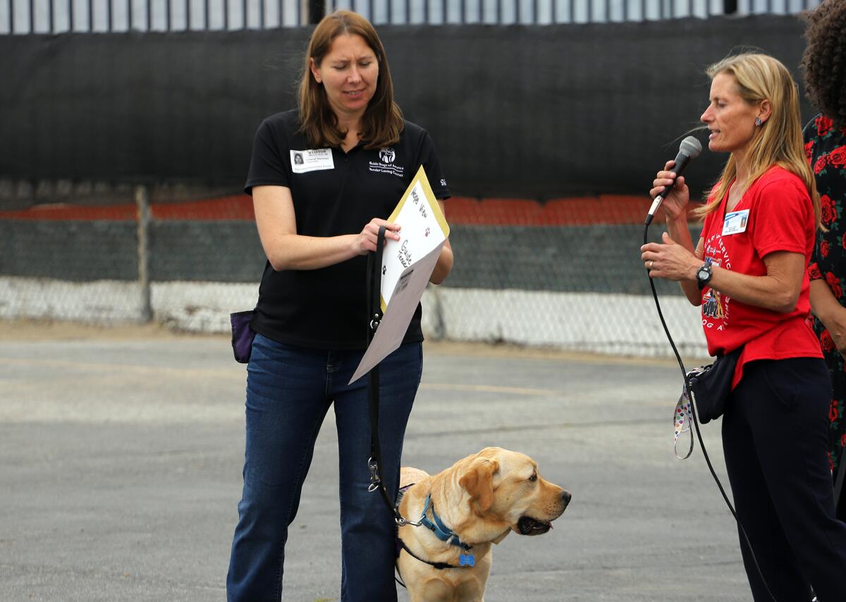 Hope View Elementary School teacher Holly Sjogren, right, gives a $2,000 check to Cheryl Herman of Guide Dogs of America.