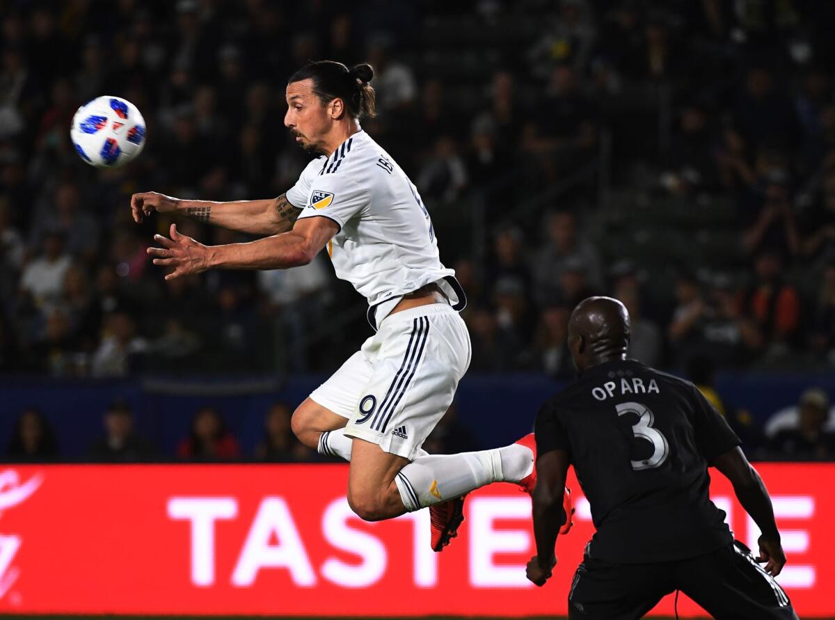 Zlatan Ibrahimovic of LA Galaxy (L) controls the ball beside Ike Opara of Sporting Kansas City during their Major League Soccer (MLS) game at the StarHub Center in Los Angeles, California, on April 08, 2018. Sporting Kansas City went on to win 2-0.