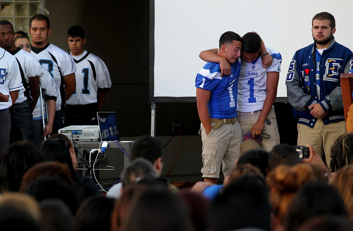 El Monte High School football players embrace during a candlelight vigil for a teammate, Adrian Castro, who was one of 10 people killed in the bus crash in Orland, Calif., last Thursday.