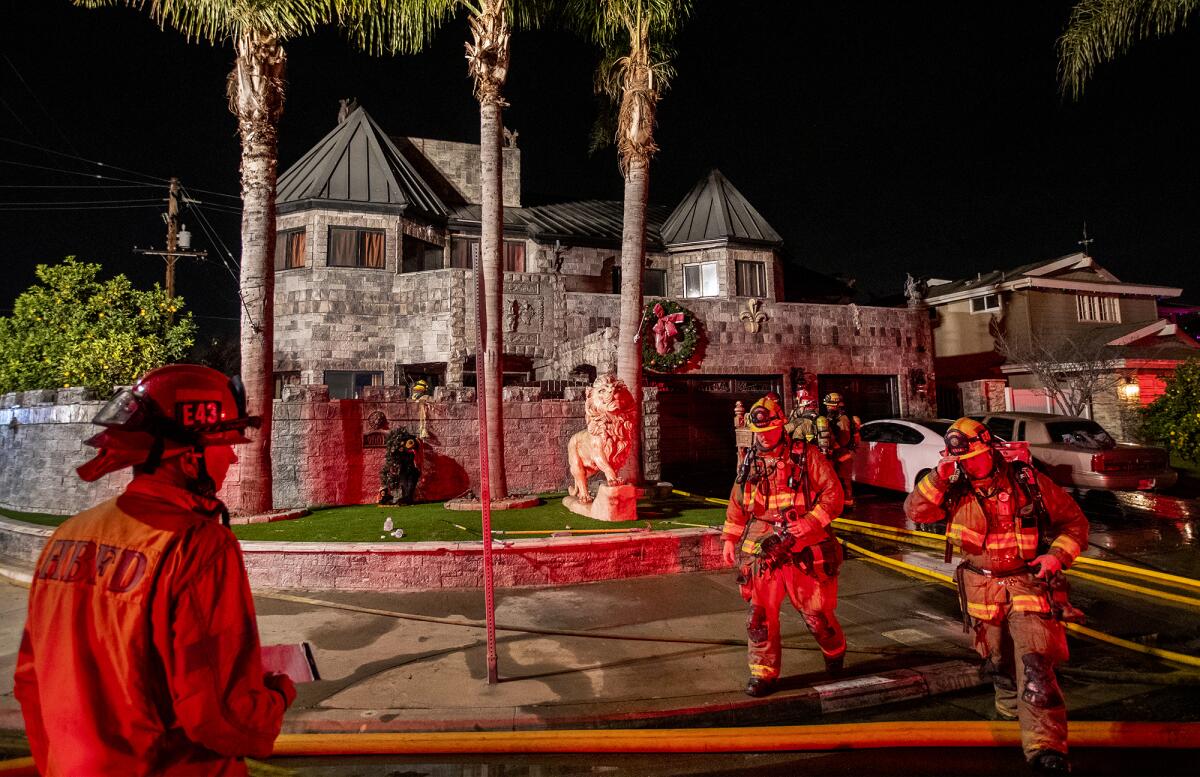 Firefighters assess the scene at the "Castle House" in Huntington Beach on Thursday night.