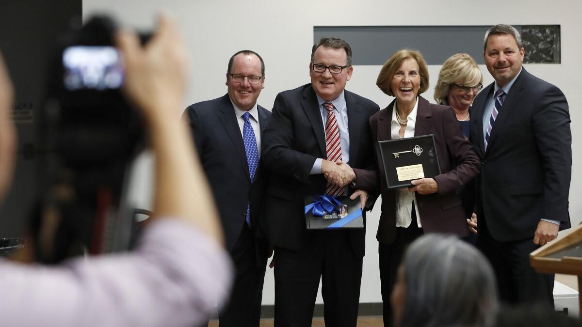Termed-out Costa Mesa Councilman Jim Righeimer, center, takes a photo with other council members as he is recognized at Tuesday's council meeting at the Costa Mesa Senior Center.