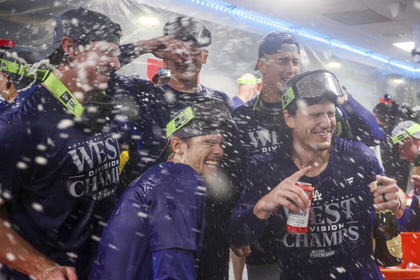 The Los Angeles Dodgers celebrate in the clubhouse after clinching the NL West title.