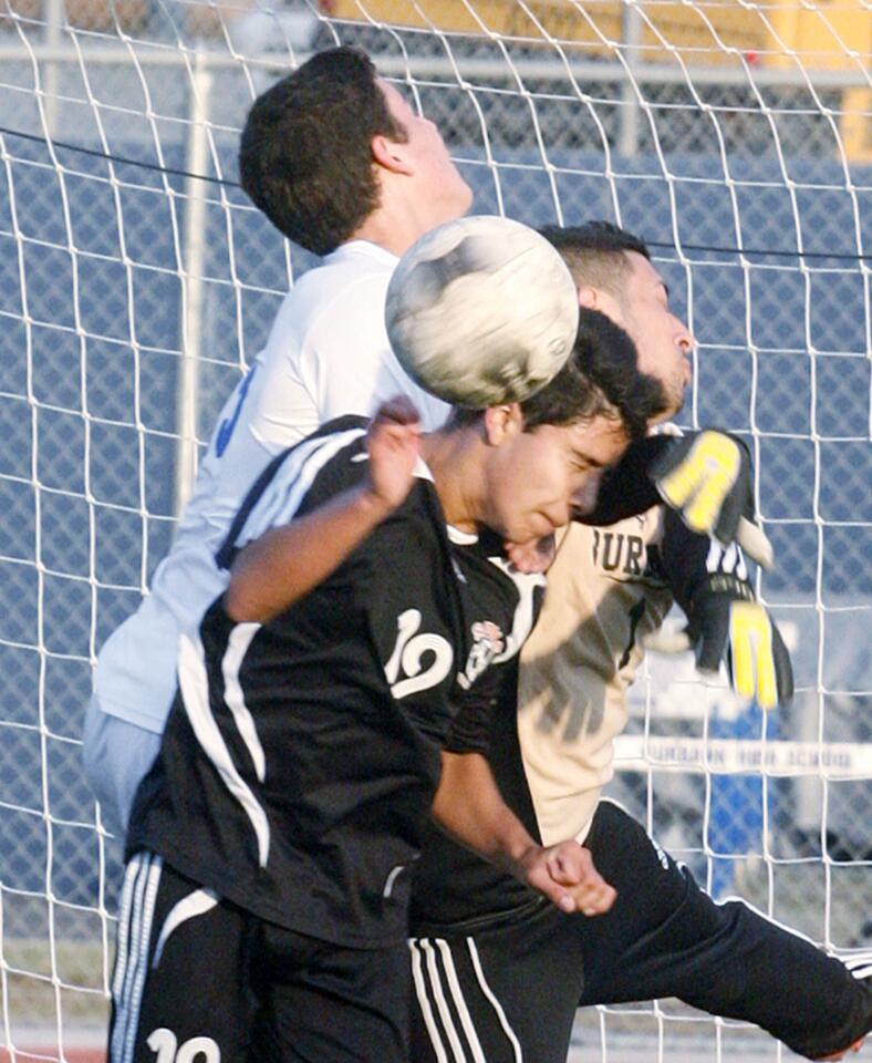 A collision in front of the Burbank goal with South Pasadena's Ramon Gutierrez attempting to put the ball passed Burbank keeper Arais Teimoorian and defender Joseph Servin in the first half in a non-league boys soccer game at Burbank High School on Tuesday, December 4, 2012.