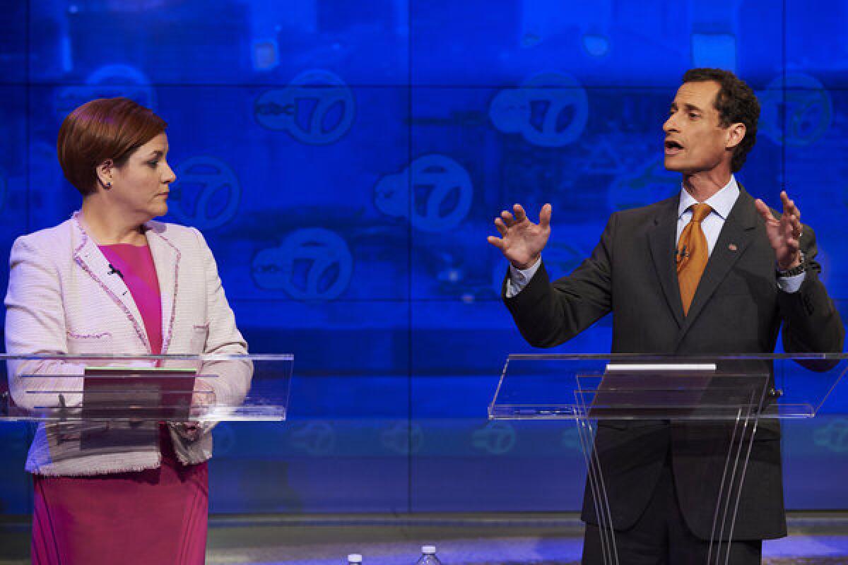 New York City Democratic mayoral candidate Christine Quinn listens as fellow candidate Anthony Weiner speaks during their first primary debate Tuesday.