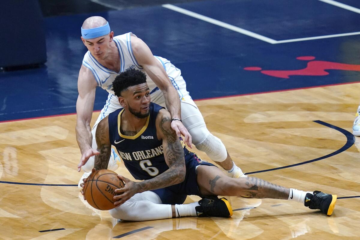 Pelicans guard Nickeil Alexander-Walker looks to pass the ball as Alex Caruso defends.