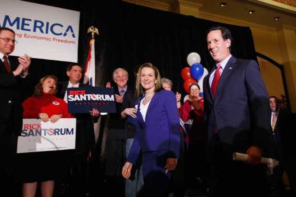 Republican presidential candidate Rick Santorum, right, takes the stage with his wife Karen during a primary election night party at the St. Charles Convention Center in St. Charles, Missouri.