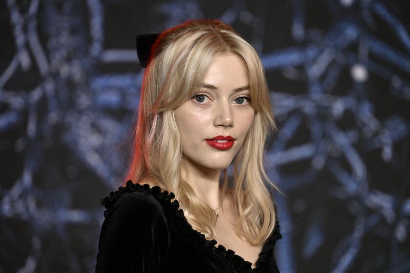 A young woman with blond hair in a black dress