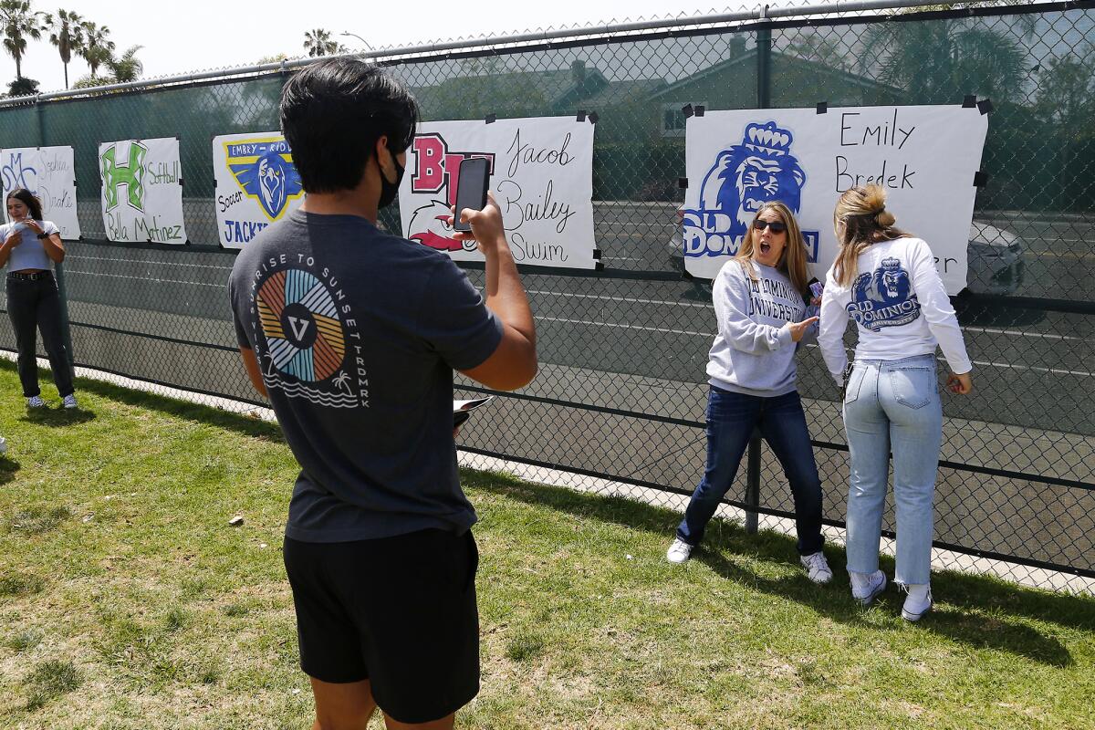 Mateo Liau, left, takes a photo of his girlfriend Emily Bredek, far right, as she poses with her mother Julia.