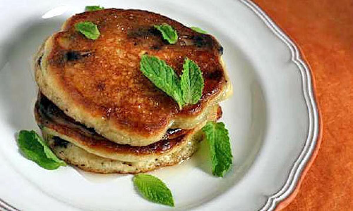 Olive oil pancakes studded with Spanish chocolate and garnished with lemon honey and fresh mint.