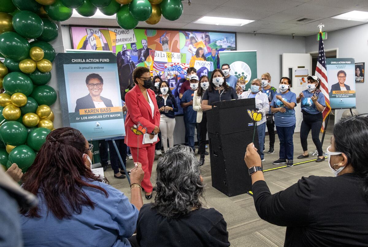 A woman is surrounded by supporters and balloons