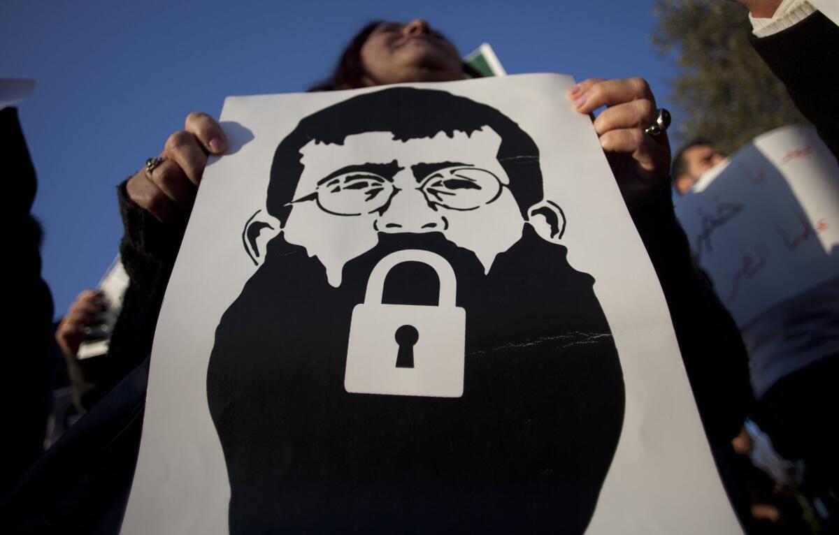 A woman holds a poster of Khader Adnan, a Palestinian inmate who was released this month after a 56-day hunger strike, during a demonstration in Jerusalem in 2012.
