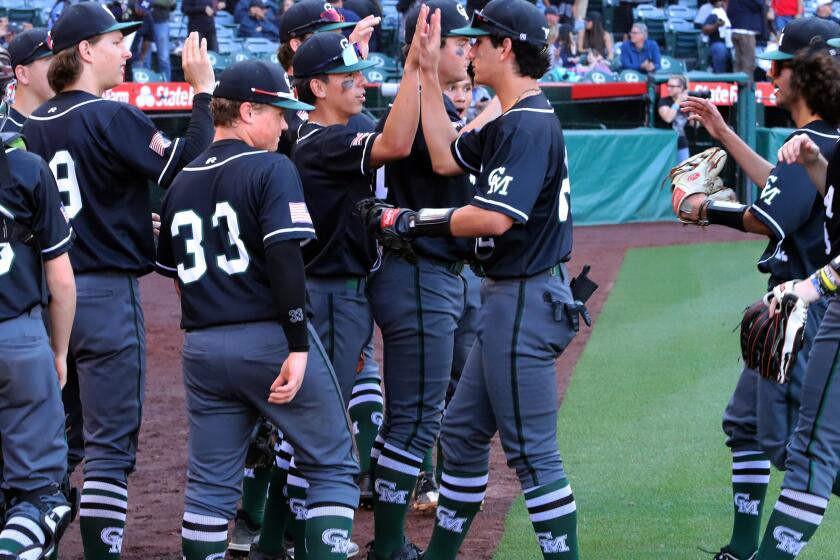 Costa Mesa's baseball team high five in celebration after winning against Estancia High School.