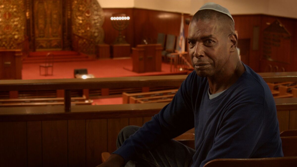 A man in a yarmulke sitting in a synagogue in the documentary “Aulcie.”