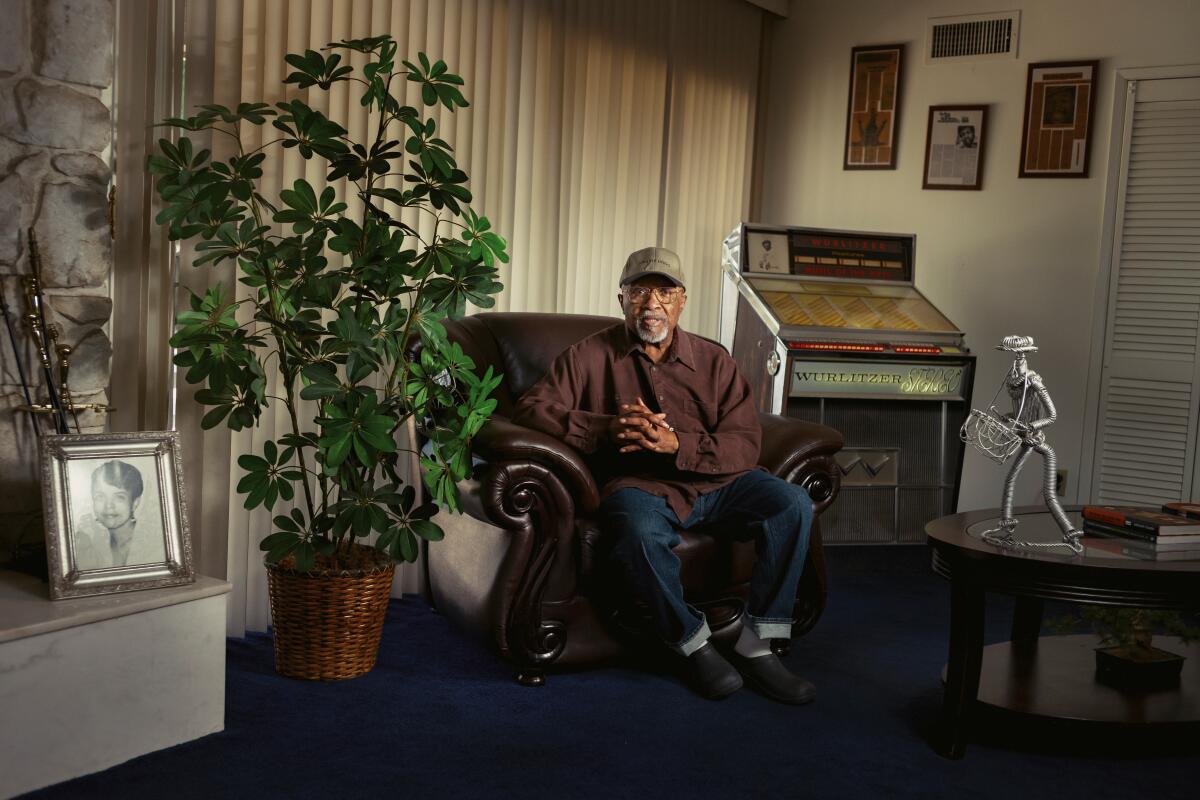 Old black man sitting on a couch in his living room