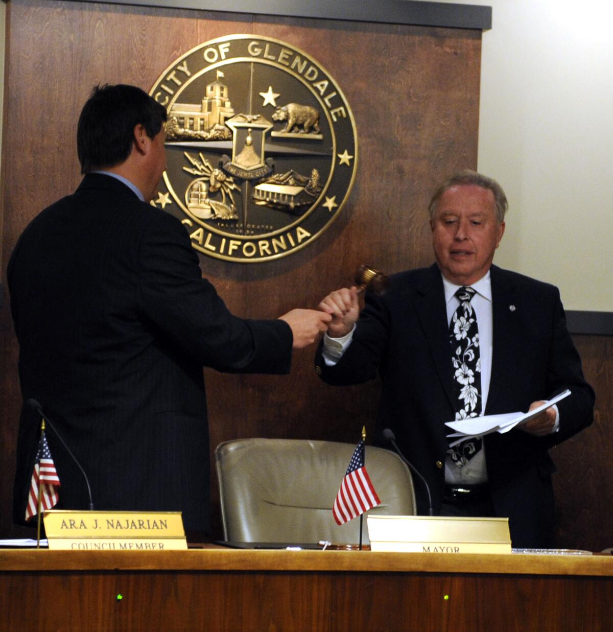 Councilman Ara Najaria, left, presents newly appointed Mayor Dave Weaver, right, with the gavel on Monday.