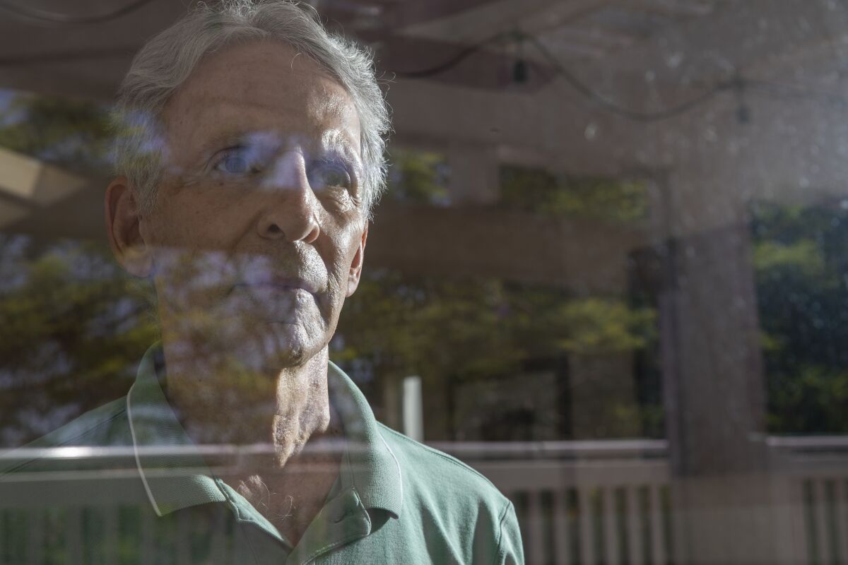 Jody Gorran looks out a glass door in his residential development. He says masks let more seniors enjoy the facilities.  