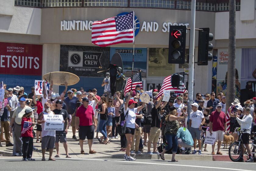 HUNTINGTON BEACH, CA -- FRIDAY, MAY 1, 2020: Thousands of protesters rally at the intersection of Main Street and Pacific Coast Highway in the``March to Open California'' to call on Gov. Newsom to relax the state's stay-at-home orders under COVID-19 in Huntington Beach, CA, on May 1, 2020. (Allen J. Schaben / Los Angeles Times)