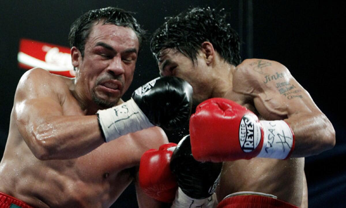 Mexico's Juan Manuel Marquez, left, punches Manny Pacquiao during their WBO welterweight title fight in November 2011. Marquez's promoter says his boxer wants to face the winner of the upcoming Timothy Bradley-Pacquiao fight.