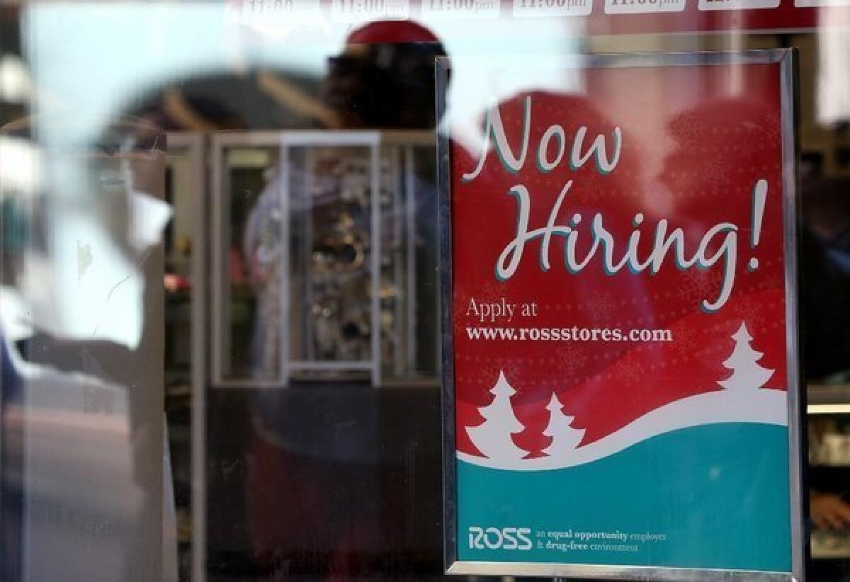 A sign advertising job openings hang in the window of a Ross clothing store in San Francisco.