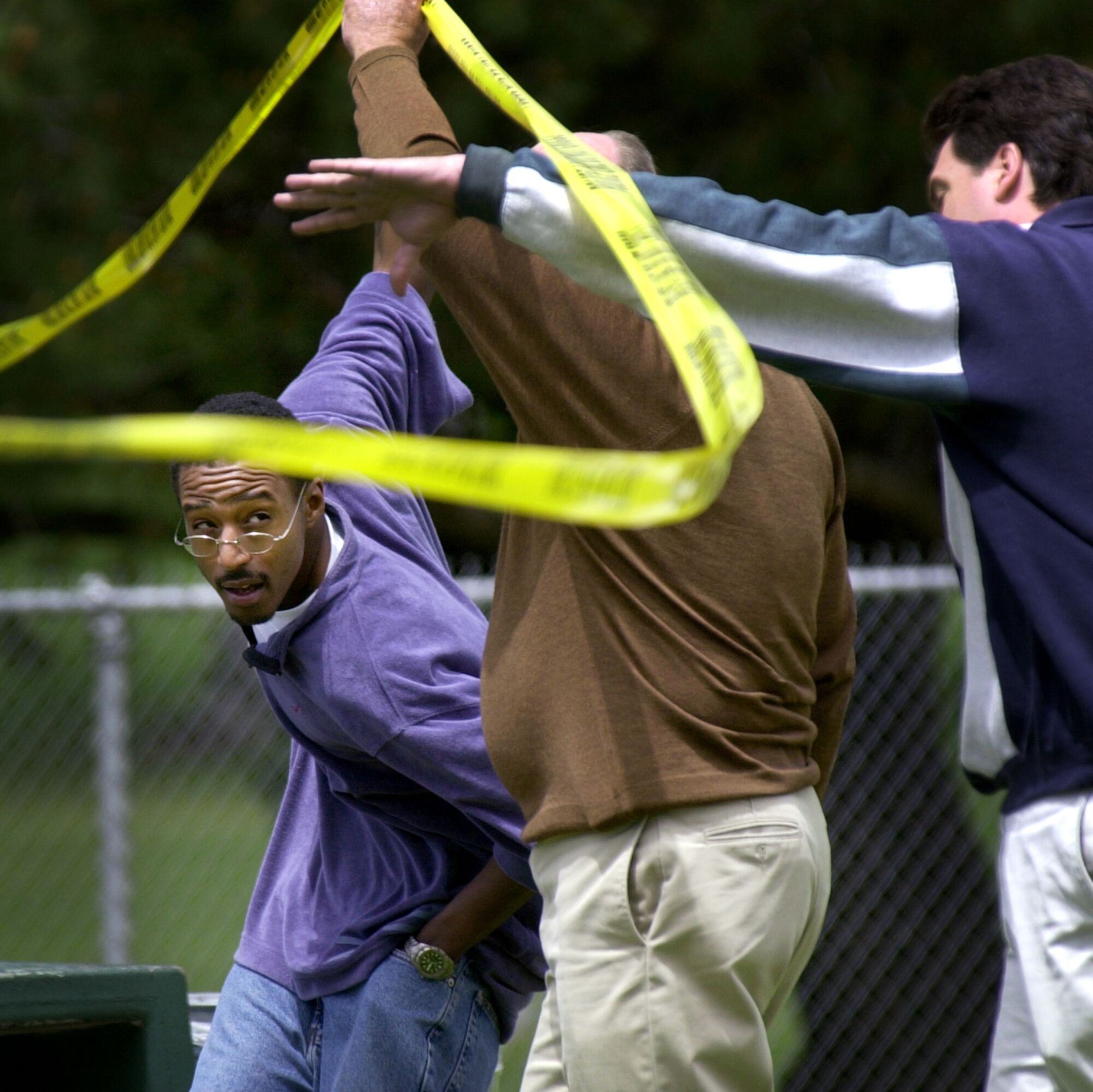 Tieray Jones ducks under police tape with San Diego police detectives.