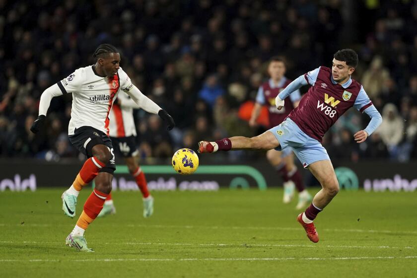 Amari'i Bill del Luton Town (izquierda), y Zeki Amdouni de Burney disputan e balón durante el partido de la Liga Inglesa en Turf Moor, Burnley, Inglaterra, el viernes 12 de enero de 2024. (Martin Rickett/PA via AP)