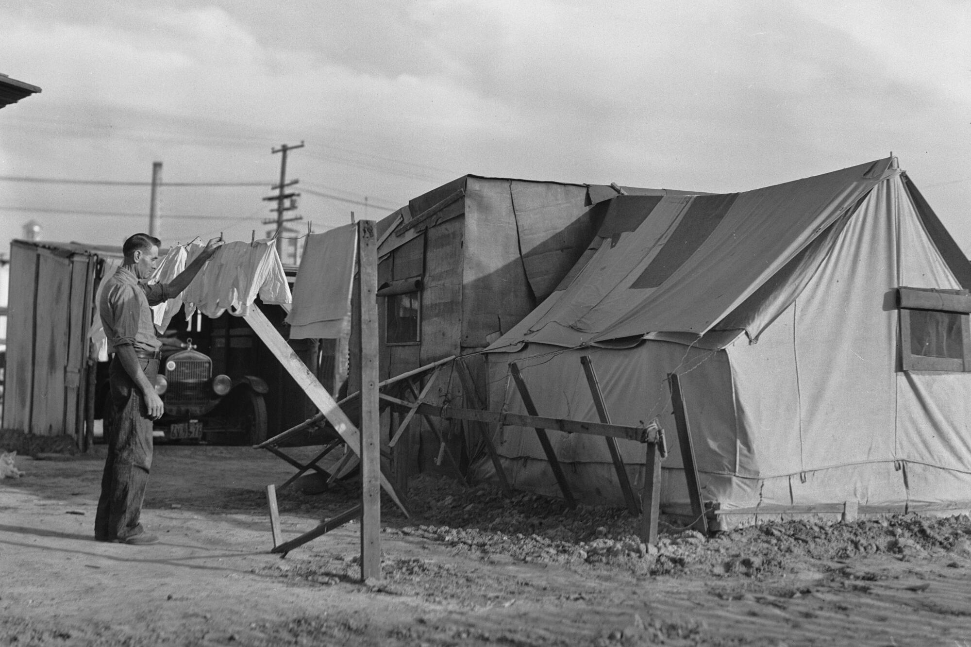 A man hangs his laundry beside his home in a shantytown.