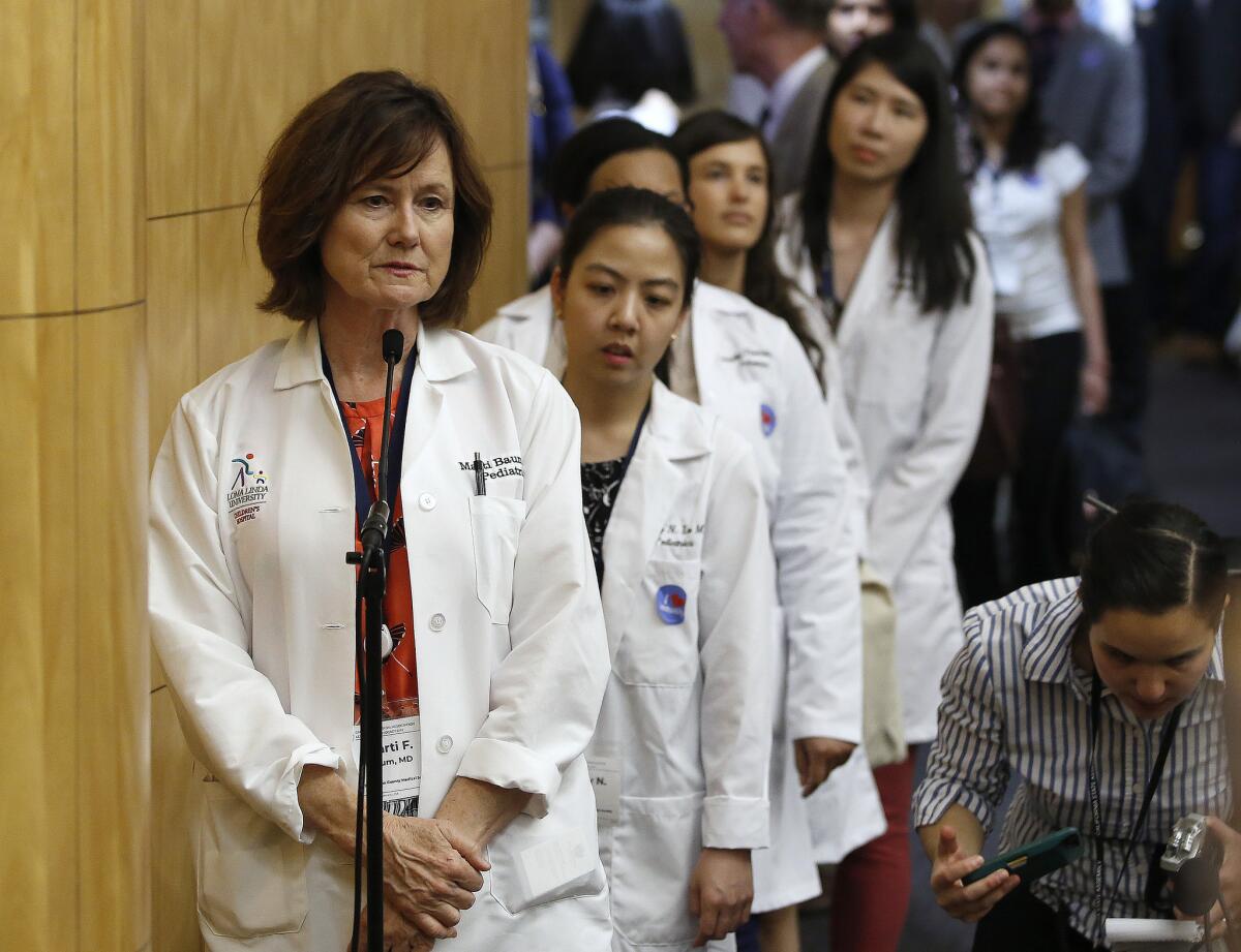 Dr. Marti Baum, left, a pediatrician, joined others at the Capitol in Sacramento to urge lawmakers to approve a proposal to give state public health officials the power to decide which children can skip their shots before attending school.