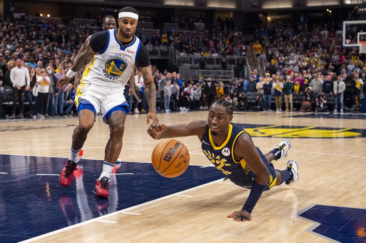 Indiana Pacers guard Caris LeVert (22) loses control of the ball after stumbling during a drive to the basket during the second half of an NBA basketball game against the Golden State Warriors in Indianapolis, Monday, Dec. 13, 2021. (AP Photo/Doug McSchooler)