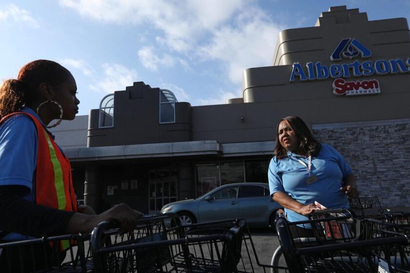 LOS ANGELES, CA - JUNE 20, 2019 - Pamela Hill, 58, right, talks with a co-worker about the possibility of another strike in front of the Albertsons store where she has worked at for the past 23 years in the Crenshaw District in Los Angeles on June 20, 2019. Hill has worked at the particular store on Martin Luther King and Crenshaw boulevards since early 2003  right before the big supermarket strike, in which she participated. 15 years later she is nearing retirement, still employed by the same grocer and planning to vote Monday to authorize leaders of the United Food and Commercial Workers union to call another strike. (Genaro Molina/Los Angeles Times)