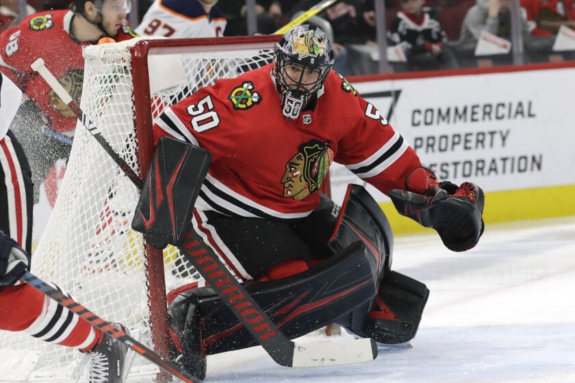 FILE - In this March 5, 2020, file photo, then-Chicago Blackhawks goalie Corey Crawford watches the puck during the second period of an NHL hockey game against Edmonton in Chicago. Lots of new faces at the New Jersey Devils training camp, with the most-well known being 36-year-old goaltender Corey Crawford, who was signed as a free agent along with defenseman Dmitry Kulikov. (AP Photo/Nam Y. Huh, File)