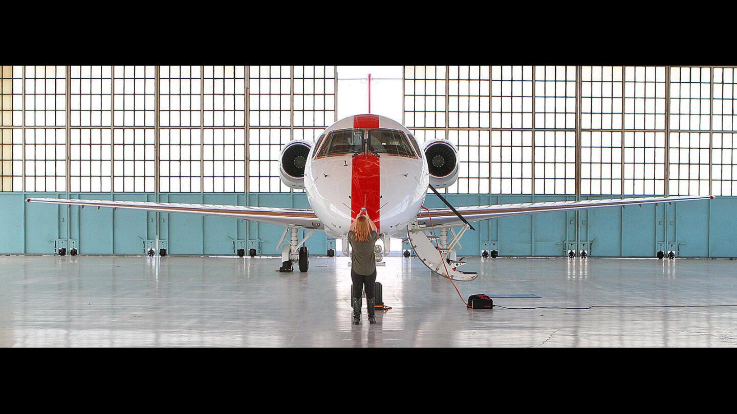 Digital marketing intern Sarah Theiss, with JetSuite out of Irvine, makes pictures for social media to publicize the new JetSuiteX flight service at Hangar 2 at the Bob Hope Airport in Burbank on Monday, April 4, 2016. JetSuite, the fourth largest private jet company in the U.S., launches JetSuiteX, a public charter operator, to offer limited scheduled flights from Burbank to the Bay Area and Las Vegas, starting April 19.