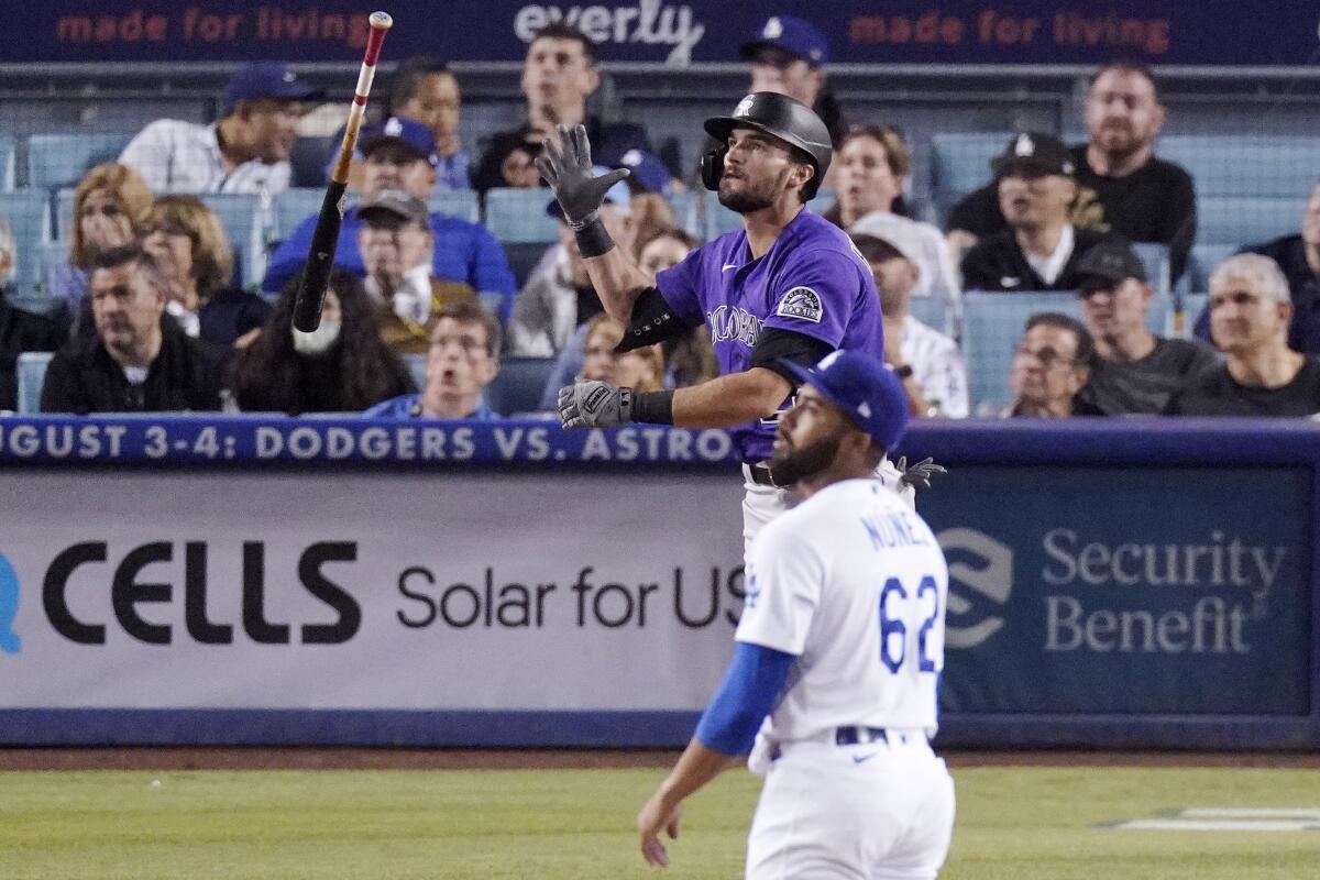 The Rockies' Sam Hilliard tosses his bat after hitting a ninth-inning solo homer off Dodgers reliever Darien Núñez.