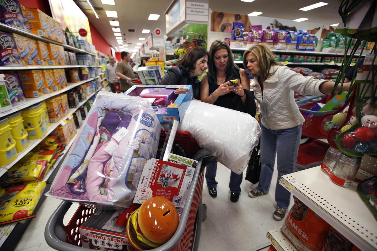 Target shoppers Kelly Foley, left, Debbie Winslow, center, and Ann Rich use a smartphone to look at a competitor's prices while shopping shortly after midnight on Black Friday last month in South Portland, Maine.