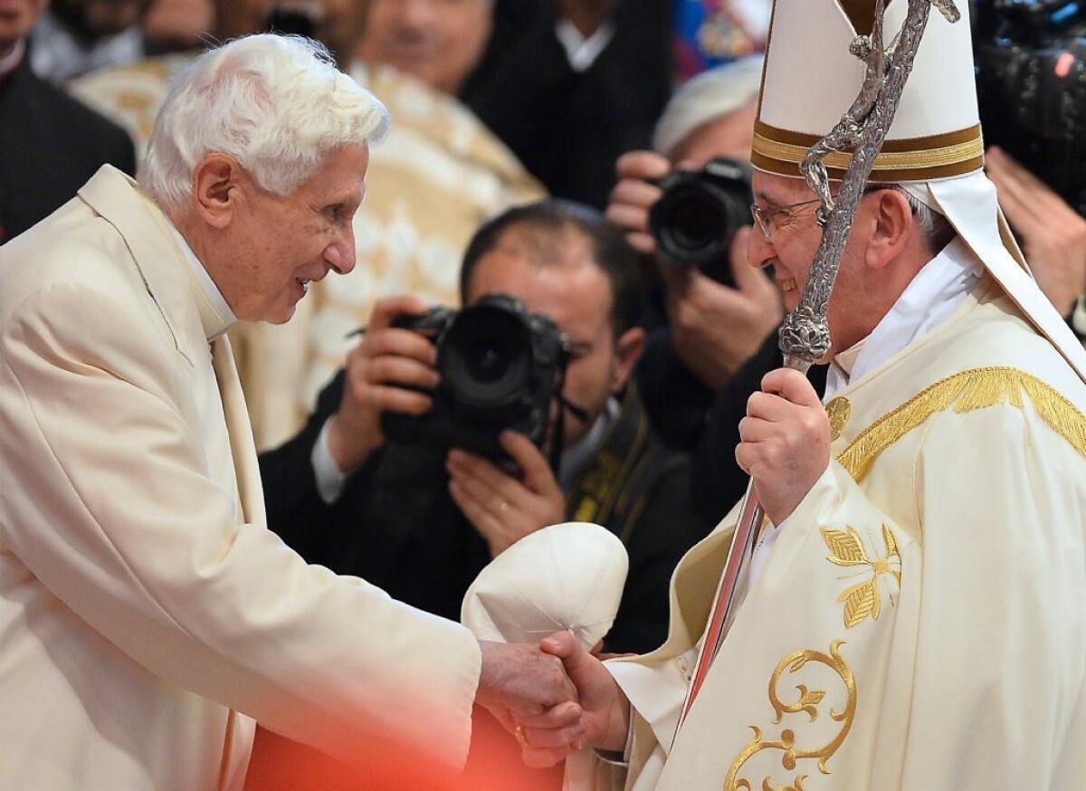 Pope Francis is greeted by Pope Emeritus Benedict XVI, left, at a consistory for new cardinals on Feb. 22.