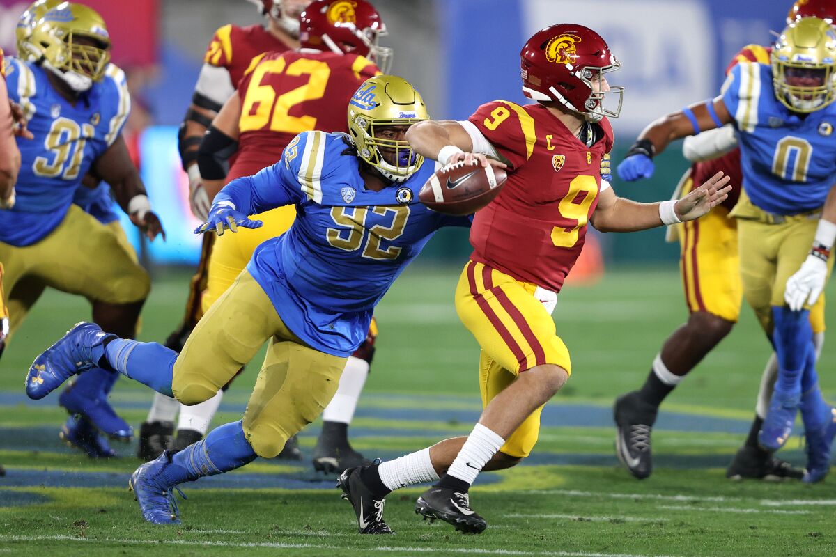 UCLA's Osa Odighizuwa pressures USC quarterback Kedon Slovis on Dec. 12 at the Rose Bowl.