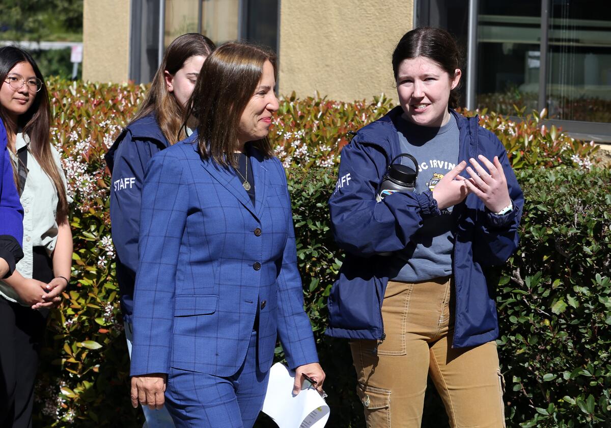 California Lt. Gov. Eleni Kounalakis walks while listening to UC Irvine political science student Kylie Halliday.