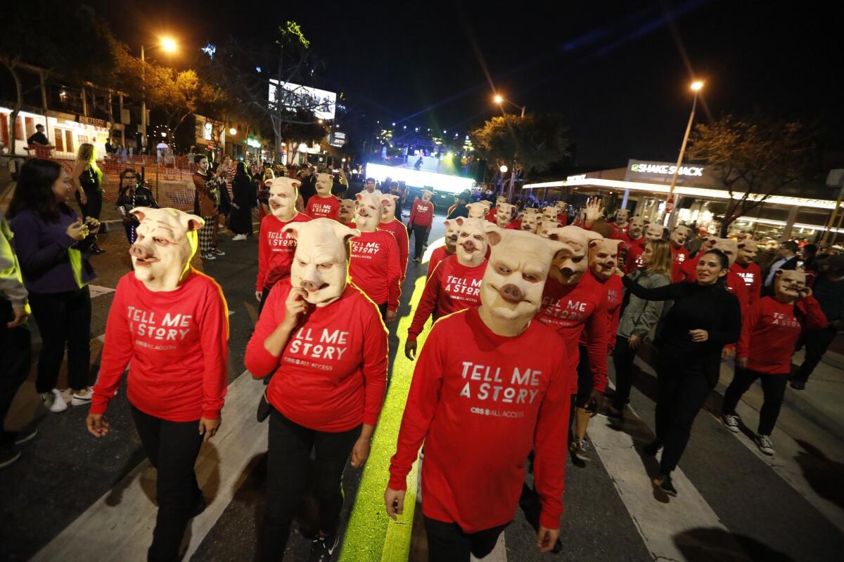 A group dressed in pig masks join the thousands of costumed revelers who participate in the Halloween Carnaval along Santa Monica Boulevard in West Hollywood. The street festival features performers, entertainment and cultural displays.