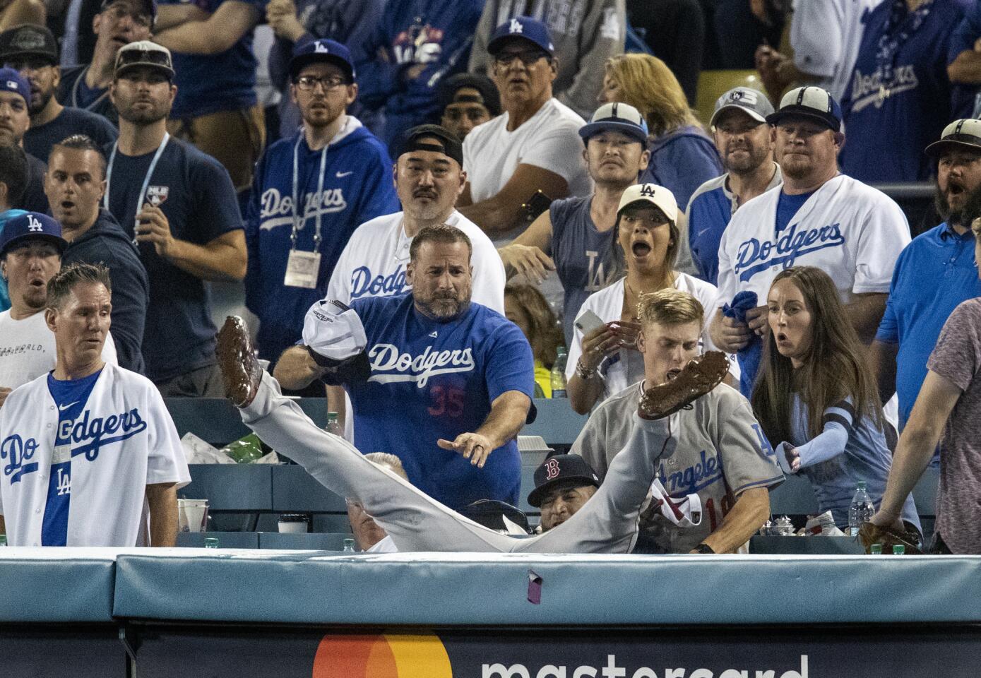 Red Sox third baseman Eduardo Nunez falls into the stands after catching a foul ball hit by Dodgers center fielder Cody Bellinger in the 13th inning.