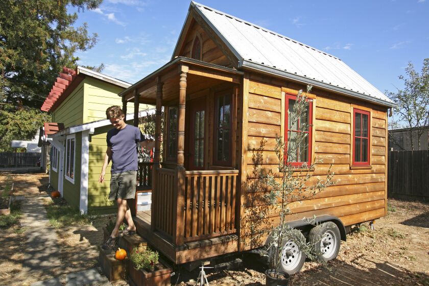 In this photo taken Oct. 14, 2010, Jay Schafer, owner of Tumbleweed Tiny Houses, exits a tiny house he built for himself in Graton, Calif. In a country where most people want to live large, Schafer helps people live small. The California homebuilder has become a leader in a small but growing corner of the American housing market: the tiny house. Schaefer, who lived in a 89-square foot house with his wife before his son was born last year, builds houses that are smaller than most people's living rooms. (AP Photo/Ben Margot)